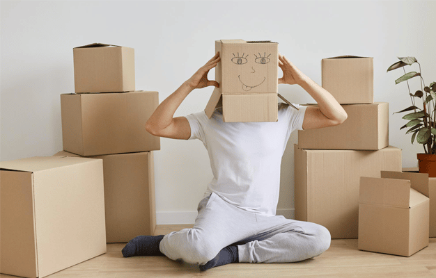 personnage la tête dans les carton pour déménager sans stress